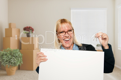 Woman with Blank Sign and House Key in Empty Room with Packed Mo