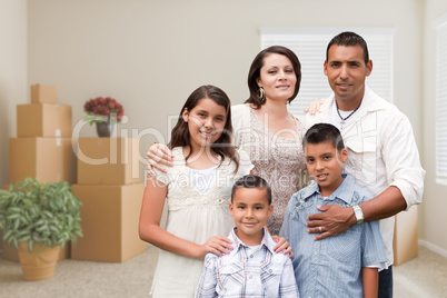 Hispanic Family in Empty Room with Packed Moving Boxes and Potte