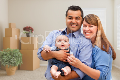 Mixed Race Family with Baby in Room with Packed Moving Boxes