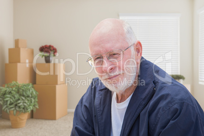 Senior Man in Empty Room with Packed Moving Boxes