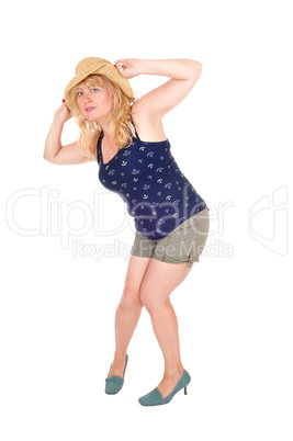 Woman standing with straw hat.