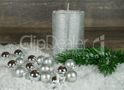 Weihnachten, silberne Kerze im Schnee mit Weihnachtskugeln