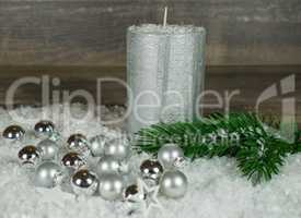 Weihnachten, silberne Kerze im Schnee mit Weihnachtskugeln