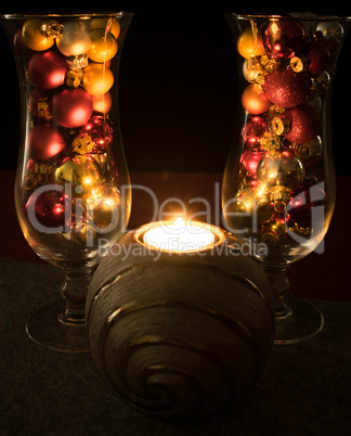 Weihnachten, mit Weihnachtskugeln gefüllte Cocktailgläser mit brennender Kerze