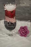 Cocktailglas im Sand mit Rosen
