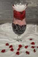 gefülltes Glas im Sand mit Rosen