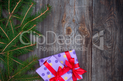 Gray wooden festive background with branches of spruce and packa