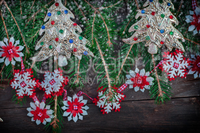 snow covered branches of spruce with Christmas toys on gray wood