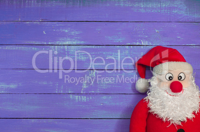 Cloth Santa Claus on a background of purple wooden surface