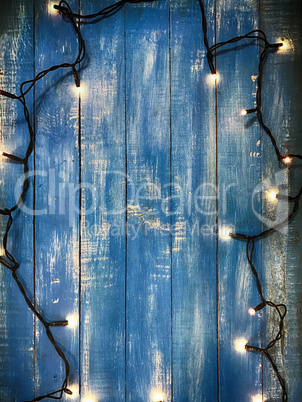 Electric garland with small paws on a blue wooden background
