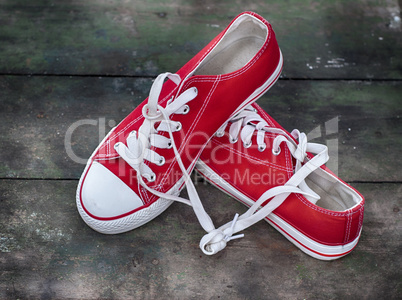 pair of red sneakers youth on an old wooden surface