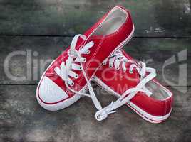 pair of red sneakers youth on an old wooden surface