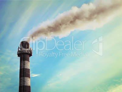 Smoke from industrial pipe on a background of blue sky