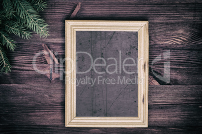 Vintage empty wooden frame with a branch of spruce in the corner