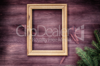 Empty wooden frame with a branch of spruce in the corner