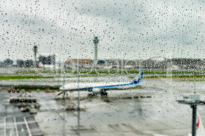 Airplane waiting on runway under rain