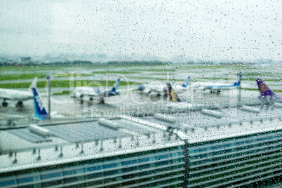 Airplanes waiting on runway under rain