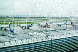 Airplanes waiting on runway under rain