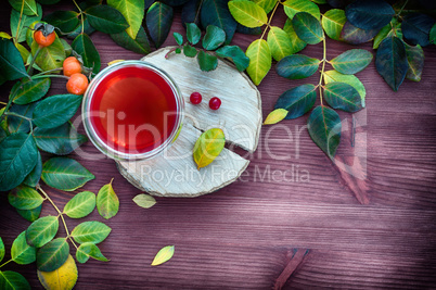 Tea in a transparent glass mug among the leaves