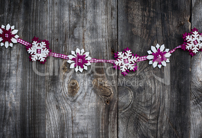 Fabric garland of snowflakes on a gray wooden surface, vintage t