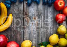 Ripe fruits lined frame on a gray wooden surface