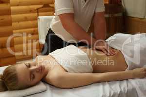 In spa center. Masseur massaging girl's belly