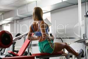Rear view of female athlete training on simulator