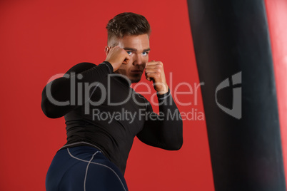 Photo of boxer fulfills blows, on red background