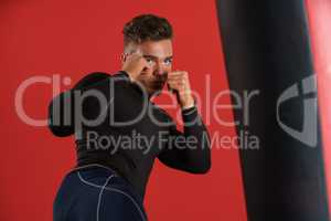 Photo of boxer fulfills blows, on red background
