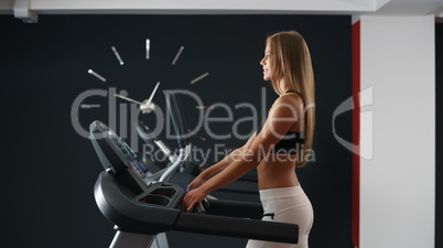 Sports concept. Girl trains on background of clock