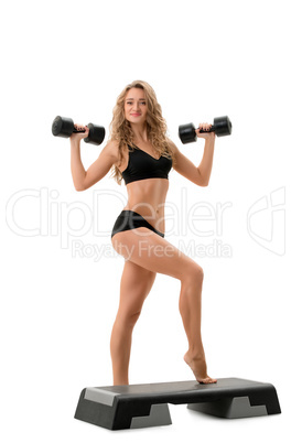 Curly athlete posing with dumbbells and stepper