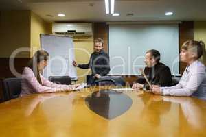 Young man leading conference for business people