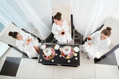 Top view of pretty girls drinking tea in spa salon
