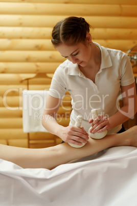 Masseuse doing Thai massage with salt bags