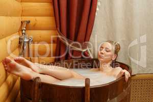 Spa. Beautiful girl taking bath with relaxing oils