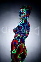 Body art. Portrait of nude girl posing in UV light