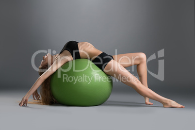 Image of slim woman trains on fitness ball