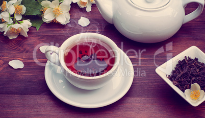 Hot black tea in a cup and saucer, vintage toning