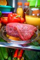 Fresh raw meat on a shelf open refrigerator