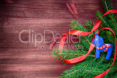 Brown wood background with spruce branch decorated with red ribb