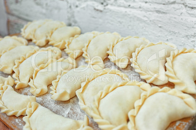 Uncooked dumplings on the kitchen board