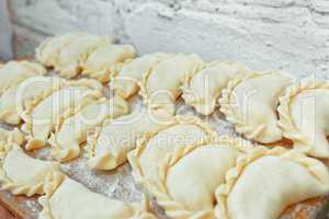 Uncooked dumplings on the kitchen board