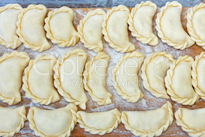 Dumplings on the kitchen board with flour
