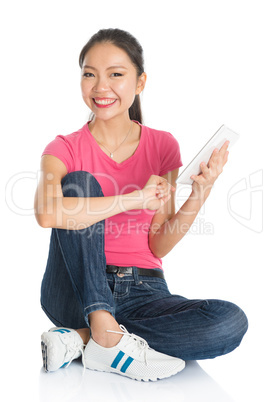 Young Asian female student using tablet pc