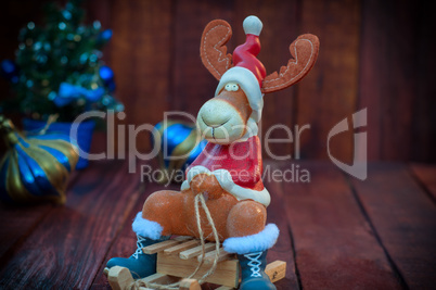 Reindeer on a wooden sledge, brown wooden background