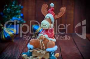 Reindeer on a wooden sledge, brown wooden background