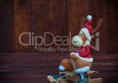 Christmas toy deer in formal attire sitting on a sledge, a brown