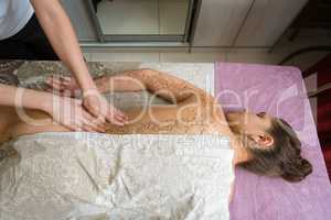 Top view of girl getting procedure body scrub