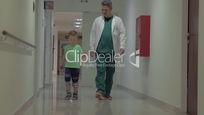Doctor and child walking in hospital corridor
