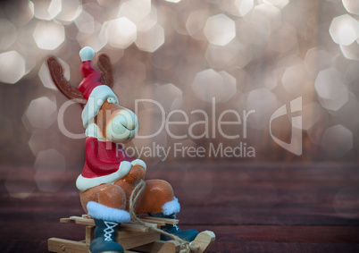 Christmas toy deer in formal attire sitting on a sledge
